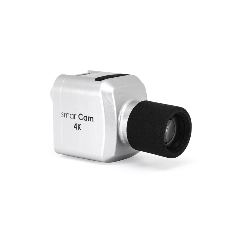 Nahaufnahme einer silbernen 4K-Kamera mit der Aufschrift 'smartCam 4K'. Die Kamera hat ein kompaktes Design mit einer schwarzen, zylindrischen Linse.